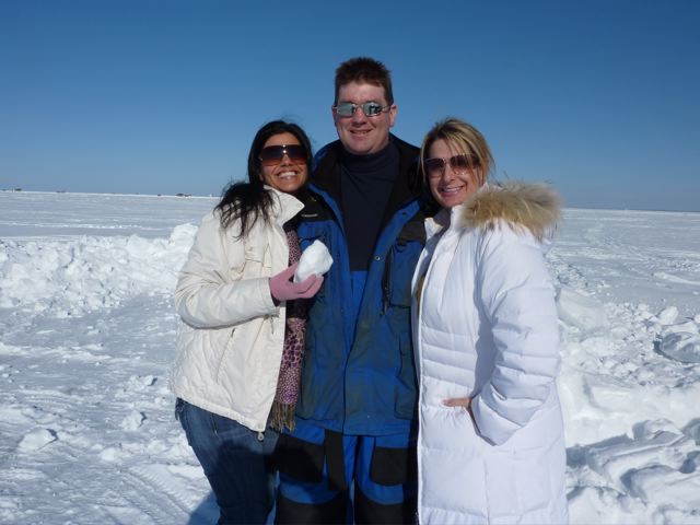 A man and two women posing in front of snow